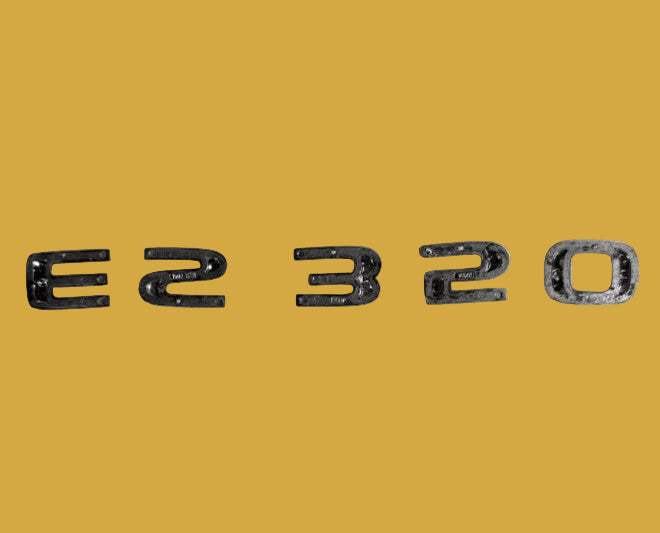 Metallic 'E2320' emblem on a textured white background