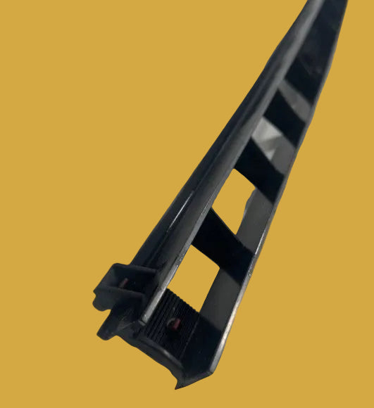 Black plastic component on a yellow background